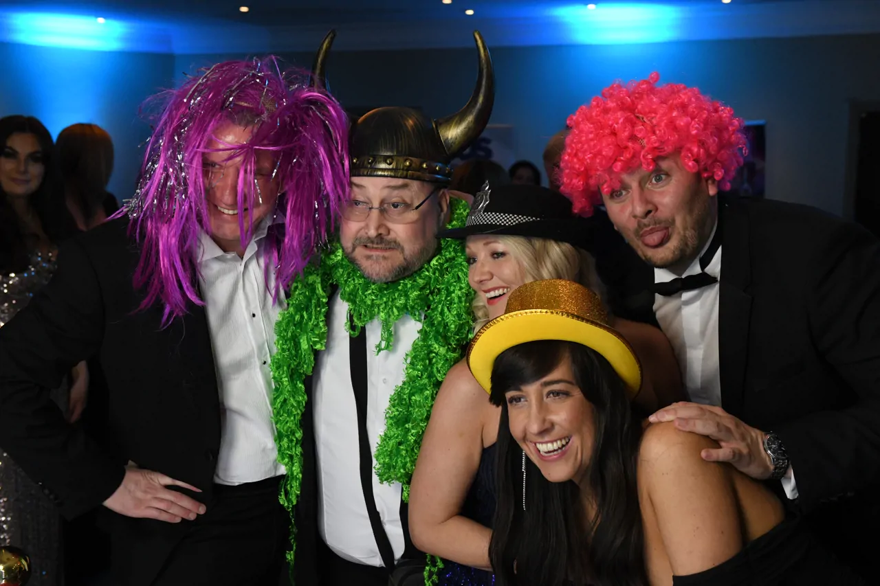 Five members of the Meridian team posing for a picture in a photobooth